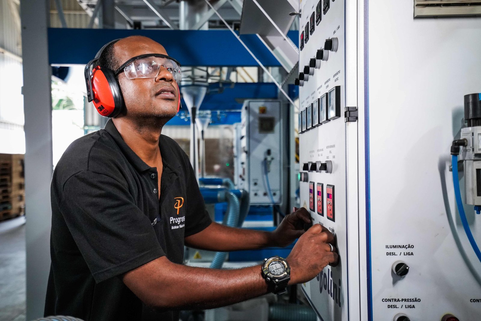 Operador da Progress controlando painel de máquina industrial