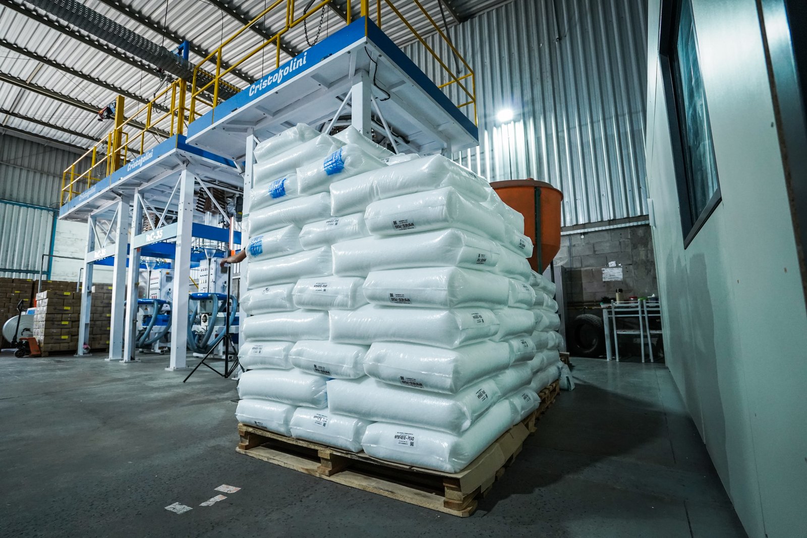 Funcionário da Progress monitorando produção de bobina plástica em máquina automatizada